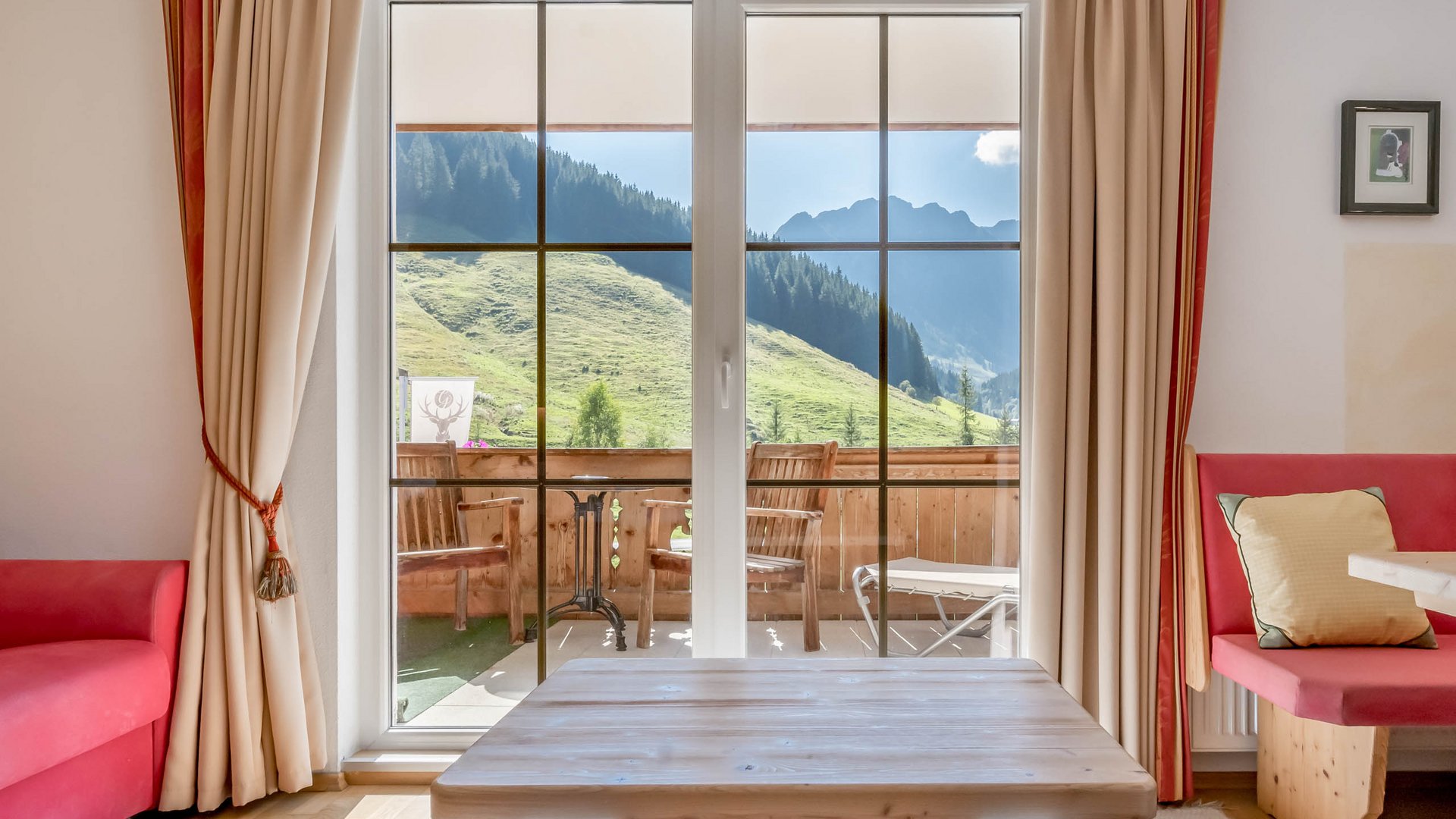 Rooms & suites in Gerlos • Der Grubacher: Eco Hotel in Tyrol Hotel room with balcony in summer overlooking the mountainside