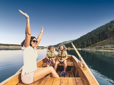 Der Grubacher • Unter den Biohotels in Tirol die beste Wahl Glückliche Frau mit Kindern in einem Ruderboot auf einem See
