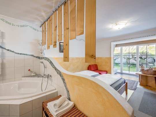 Rooms & suites in Gerlos • Der Grubacher: Eco Hotel in Tyrol Hotel room with bathtub, double bed, and terrace