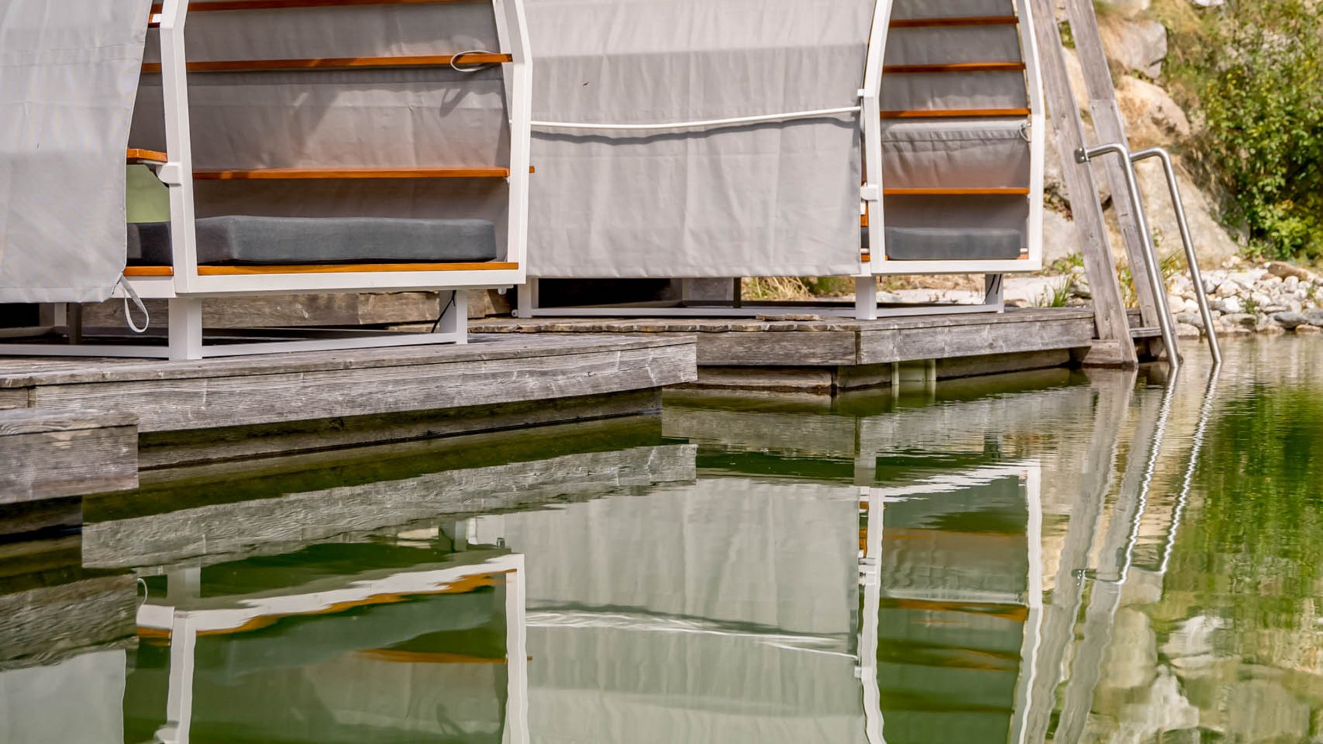 Our water world in Gerlos • Der Grubacher: Eco Hotel in Tyrol Garden lounger with reflection in the swimming pond