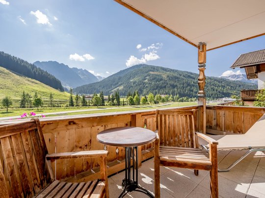 Rooms & suites in Gerlos • Der Grubacher: Eco Hotel in Tyrol Balcony with garden furniture and view of meadows and mountains