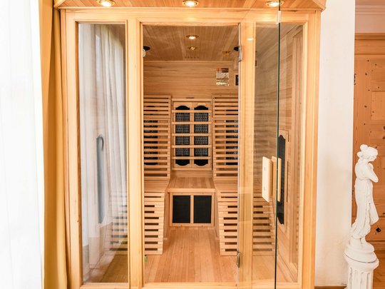 Rooms & suites in Gerlos • Der Grubacher: Eco Hotel in Tyrol Large infrared cabin in a hotel room with carpet and statue