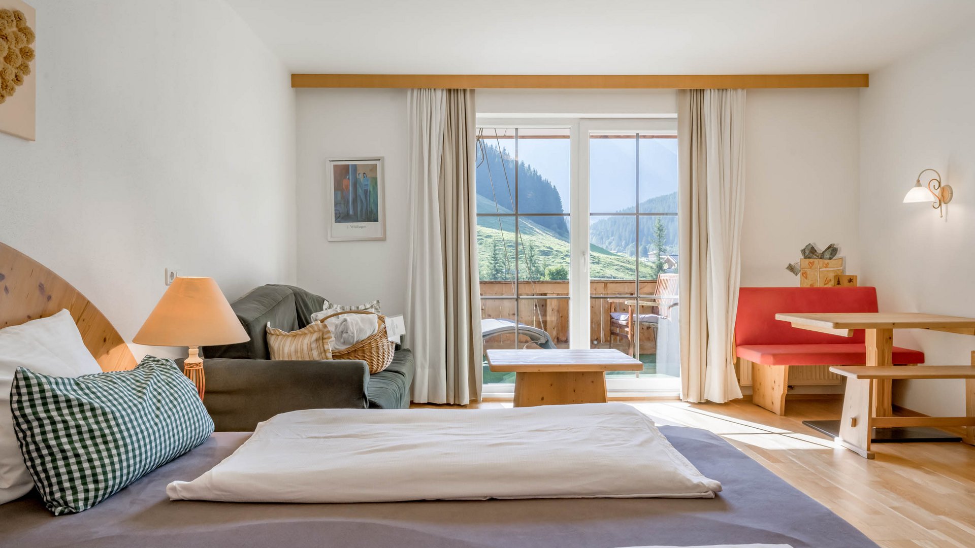 Rooms & suites in Gerlos • Der Grubacher: Eco Hotel in Tyrol Hotel room with double bed, sofa, dining table, and balcony with hanging swing