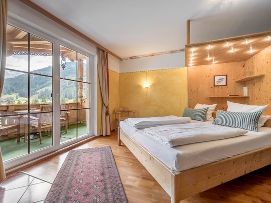 Rooms & suites in Gerlos • Der Grubacher: Eco Hotel in Tyrol Hotel room with double bed and balcony with a view