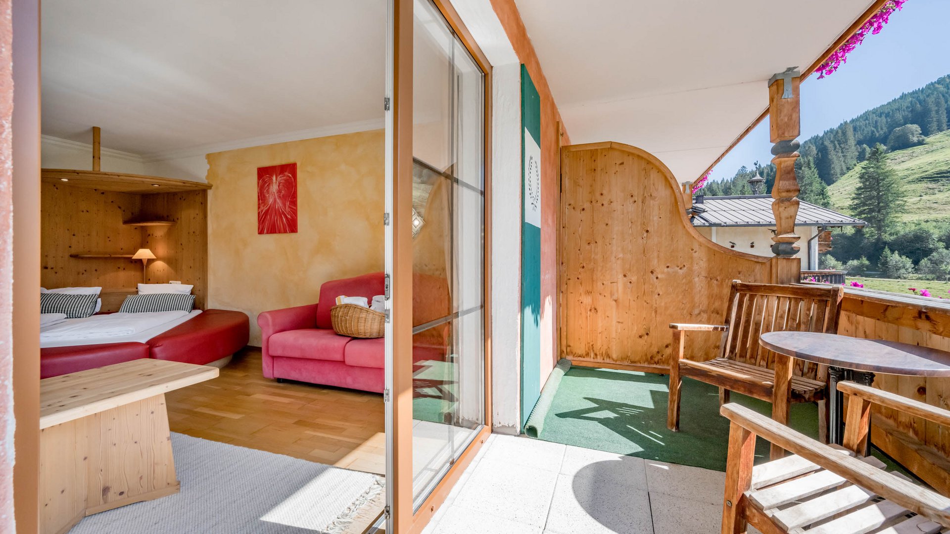 Rooms & suites in Gerlos • Der Grubacher: Eco Hotel in Tyrol Balcony in a hotel room with double bed and couch